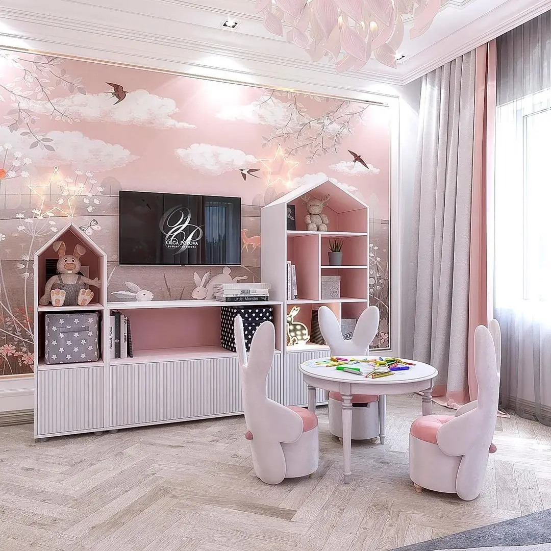 A pastel-themed children's room with bunny-shaped chairs around a small round table, house-shaped shelves brimming with toys, and a TV on a wall adorned with bird and tree murals. Light flows in from a window, creating an enchanting space reminiscent of the 17 Pink Bedrooms Fit for a Princess.