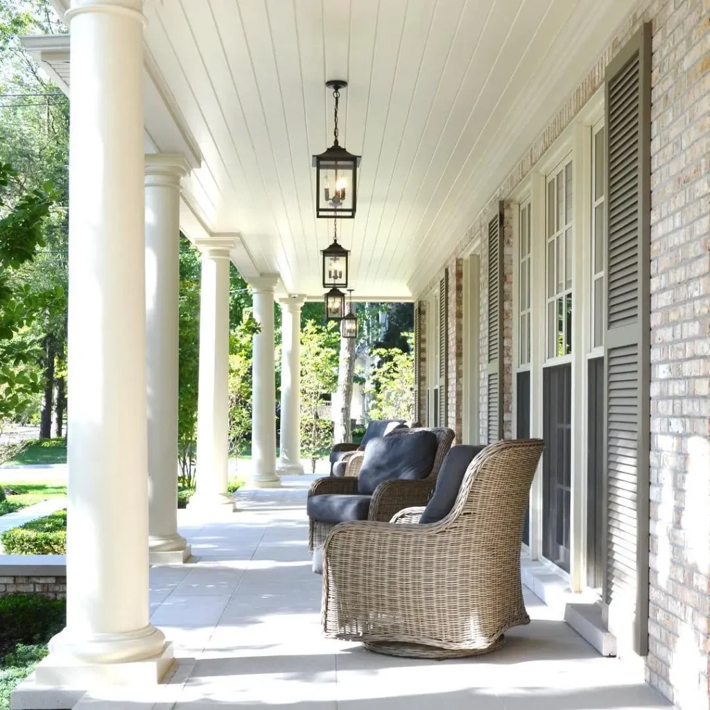 a long porch with seating and the ceiling-mounted lantern lights on can easily create a cozy and welcoming space even during the day as in this example